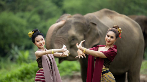 Portrait of smiling girls in front of animals