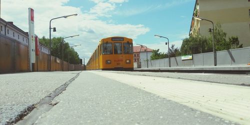 View of railroad tracks by street in city