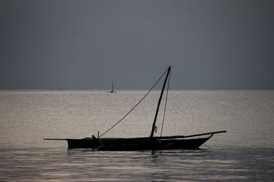 Sailboat in sea against clear sky