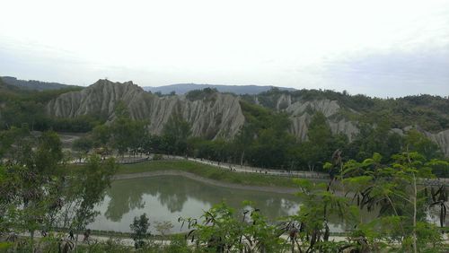 Scenic view of trees and mountains against sky