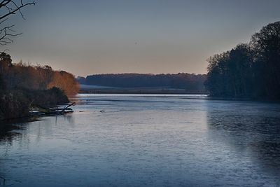 Scenic view of lake against sky at sunset