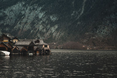 Scenic view of lake by houses against sky