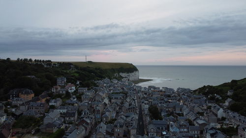 High angle view of townscape by sea against sky