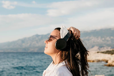 Portrait of woman with sunglasses against sky