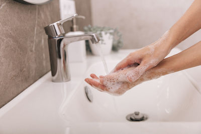 Washing hands under the flowing water tap. hygiene concept hand detail. washing hands rubbing