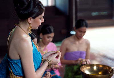 Thai women in ancient costumes in the ayutthaya period in an old house along with thai sweet food