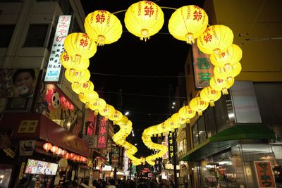 Low angle view of illuminated lanterns hanging at night