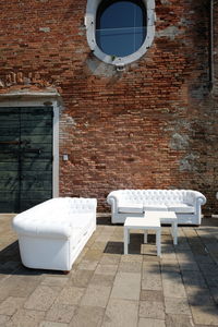 White chair and window on brick wall