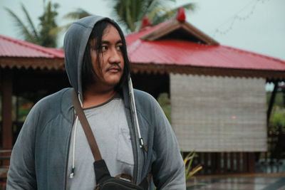 Portrait of young man standing on roof of building
