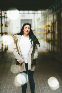 Portrait of woman standing against wall