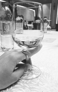 Close-up of hand holding wine glass on table