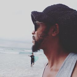 Portrait of young man on beach against sky