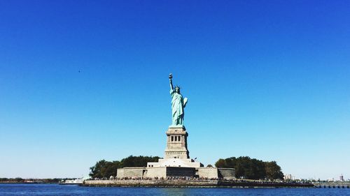 Low angle view of statue of liberty against blue sky