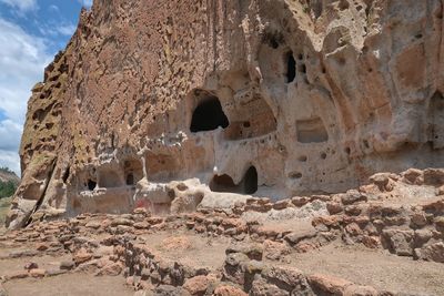 Landscape of a cliff face with holes and rooms in bandelier national monument