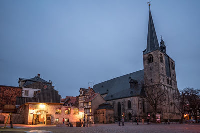 Illuminated buildings against sky at dusk