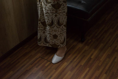 Low section of woman standing on wooden floor