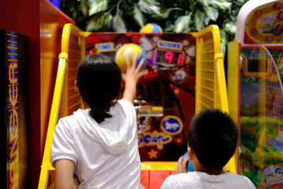 Siblings playing arcade game at playground