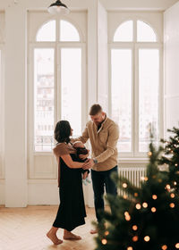 Full length of couple standing against window