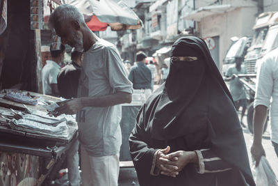 People at market stall in city