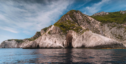 Rock formations by sea against sky