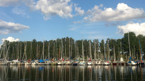 Sailboats moored in sea against sky