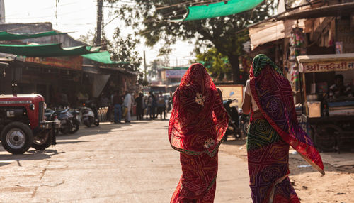 Rear view of people standing on street in city