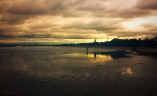 Scenic view of beach against cloudy sky
