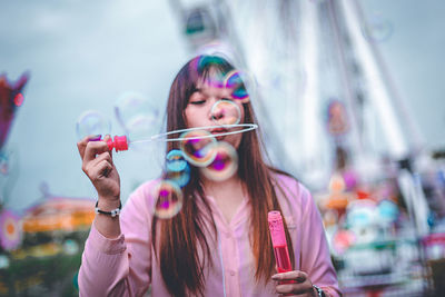 Woman blowing bubbles in city