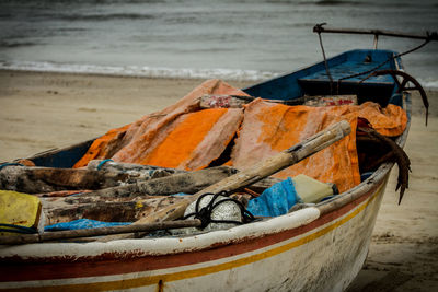 Abandoned boat moored on beach