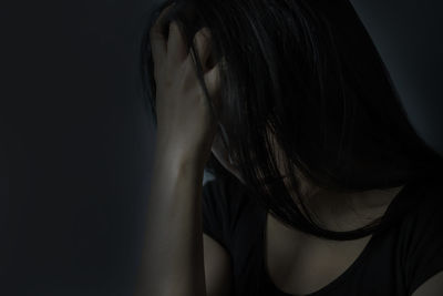 Close-up of mid adult woman with head in hands at darkroom