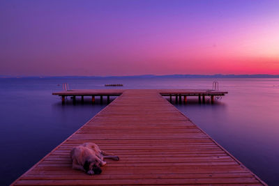 Pier over sea against sky during sunset