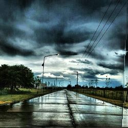 Railroad track against cloudy sky