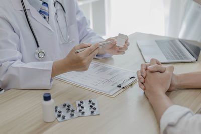 Midsection of doctor working on table