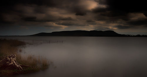 Scenic view of lake against cloudy sky