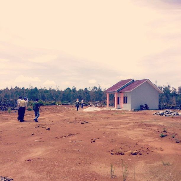 sky, sand, building exterior, architecture, built structure, cloud - sky, beach, landscape, men, lifestyles, leisure activity, cloudy, house, walking, person, nature, field, cloud, day