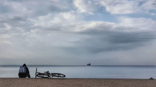 People sitting on beach against sky