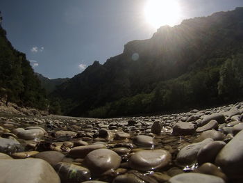 Scenic view of pebbles and mountains against sky