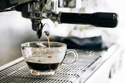 Close-up of coffee pouring in glass