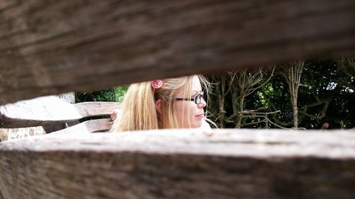 Woman seen from between wooden planks