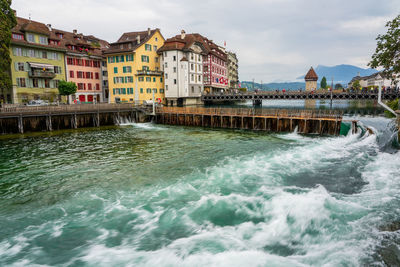 River by buildings against sky