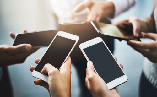 Cropped hands of woman using mobile phone