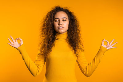 Portrait of smiling woman against yellow background