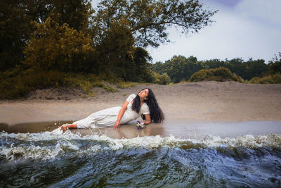 Rear view of couple relaxing on shore