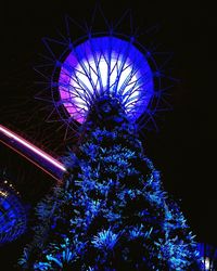 Low angle view of illuminated blue sky at night