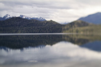 Scenic view of lake by mountains against sky