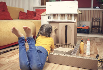 Rear view of woman sitting on table at home