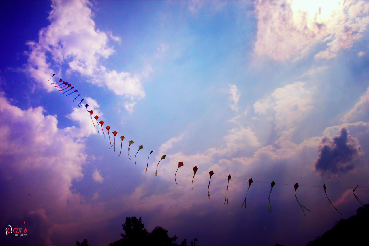 low angle view, sky, flying, cloud - sky, mid-air, cloud, silhouette, flock of birds, cloudy, blue, nature, bird, day, outdoors, no people, in a row, freedom, animal themes, beauty in nature