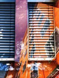 Low angle view of painted building wall and window shutters