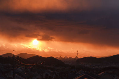 Silhouette mountain against dramatic sky during sunset