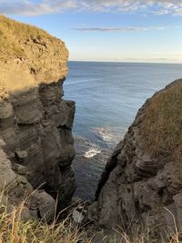 Scenic view of rocks in sea against sky